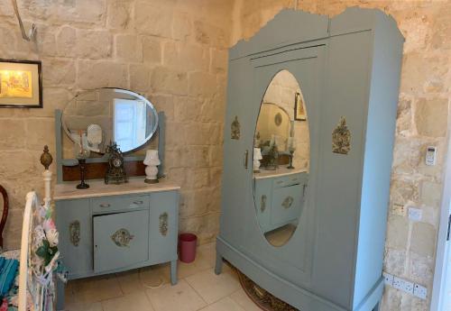 莫斯塔Unique House of Character in centre of Mosta的浴室设有镜子和蓝色橱柜