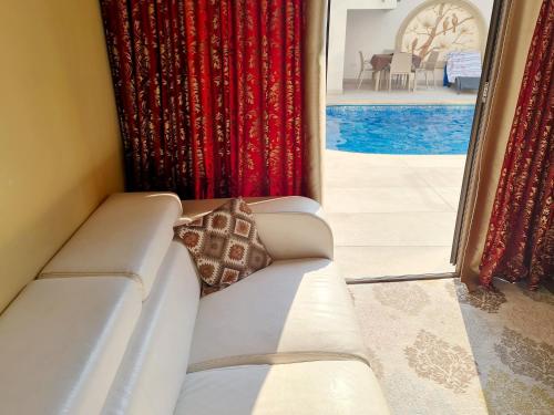 凯里尼亚SOFIA BOUTIQUE HOTEL的配有红色窗帘的房间里一张白色的沙发