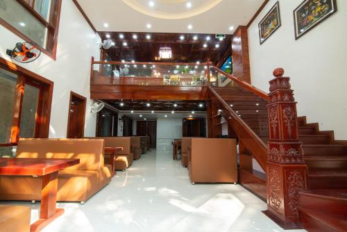 洞海Minh Quang Hotel的大堂设有楼梯、沙发和桌子