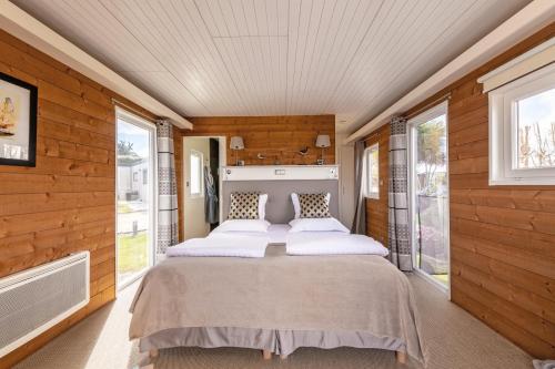 塞比瑞尔Le Theven的木墙和窗户的客房内的一张床位