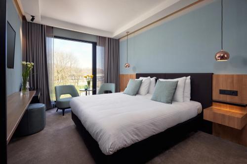 霍林赫姆Hotel Gorinchem的配有一张床、一张书桌和一扇窗户的酒店客房