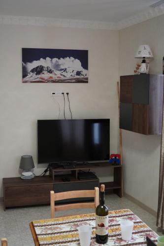 久姆里Aragats Hostel & Guest House的客厅配有平面电视和桌子。