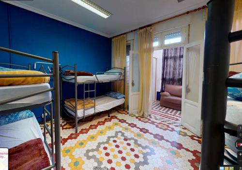 特鲁埃尔Albergue Internacional de Teruel City Backpackers的一间卧室设有双层床和蓝色的墙壁