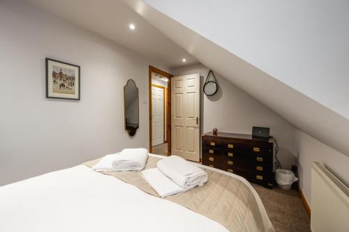 丁沃尔Aldo's Place的一间卧室配有一张带白色床单的床和梳妆台。