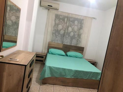 都拉斯Apartament rohelio shkembi kavajes的一间小卧室,配有一张床和镜子