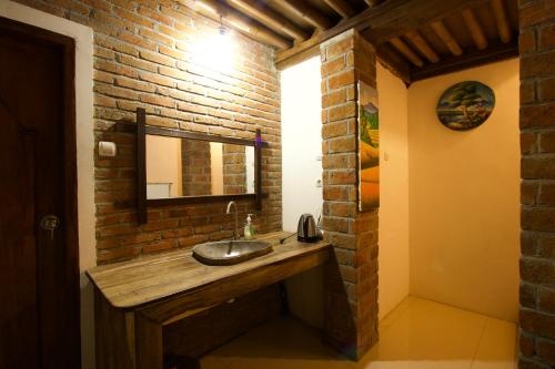 特特巴图睦民宿的一间带水槽和砖墙的浴室