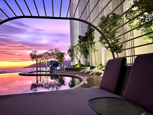 哥打京那巴鲁The Shore CBD Kota Kinabalu By LAXZONE SUITE的享有带游泳池和日落的建筑景致