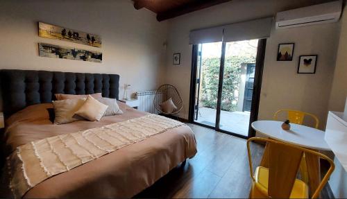 查克拉斯德科里亚Moderno departamento para dos personas en Chacras de Coria的一间卧室配有一张大床和一张桌椅