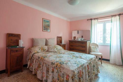 QuaraticaDaFramanco2 Country house close to 5 Terre的一间卧室配有一张床、一个梳妆台和一扇窗户。