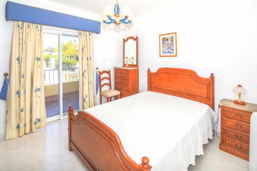 阿玛考德佩拉Olival Beach Villa with Pool walking distance to Beach的一间卧室配有一张床、一个梳妆台和一扇窗户。