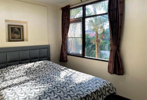 华欣Golf-Sea-City Guest House的一间卧室设有一张床和一个窗口