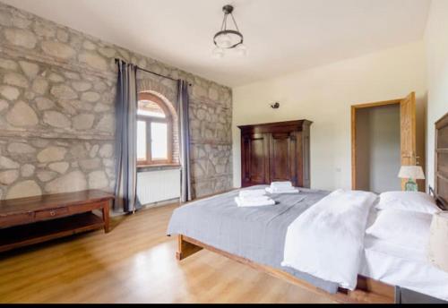 KardanakhiElizbar Talakvadze Winery的一间卧室设有一张大床和石墙
