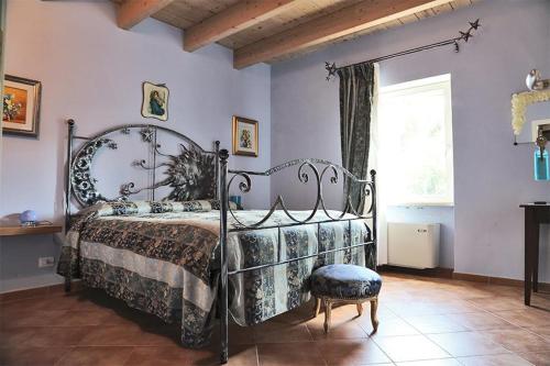 MergoAgriturismo Colle delle Stelle的一间带金属床和窗户的卧室