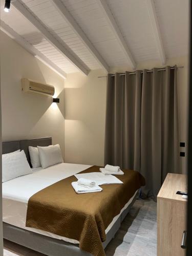 卡西奥皮Saint Spiridon Hotel的一间卧室配有一张床,上面有两条毛巾