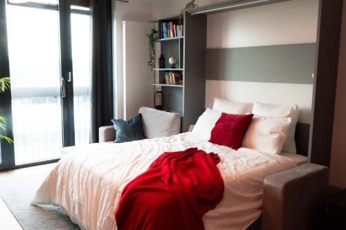 阿尔泽特河畔埃施Industrial Apartment in Belval the University City的卧室配有带红色枕头的大型白色床