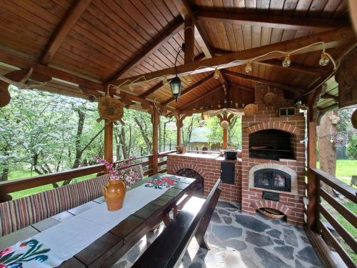 博尔沙Casa din livada的室外庭院设有砖砌壁炉、桌子和椅子。