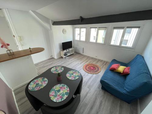 加来Appartement Calais Nord的客厅配有蓝色的沙发和桌子