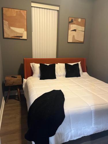 芝加哥Rustic Mix的一间卧室配有一张大床,配有白色床单和黑色枕头。