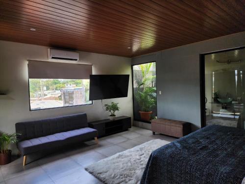 康塞普西翁德阿塔科罗斯波尔图尼斯蒂阿塔克宾馆的一间卧室配有一张床和一台平面电视