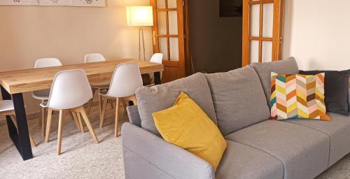 隆达Apartamento Dama Centro的客厅配有灰色的沙发和木桌
