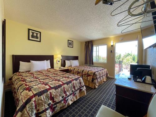 瓦列霍Motel 7 - Near Six Flags, Vallejo - Napa Valley的酒店客房设有两张床和电视。