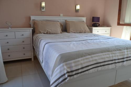 德尔锡伦西奥海岸Gîte PERLE D'OPALE的一间卧室配有一张大床和一个梳妆台