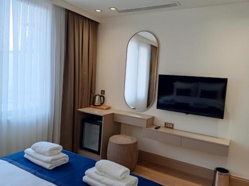伊斯坦布尔Taksim Bosphorus Hotel的酒店客房,配有床和镜子