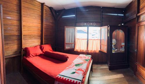 武吉丁宜江东希拉廊民宿的木制客房内的一张床