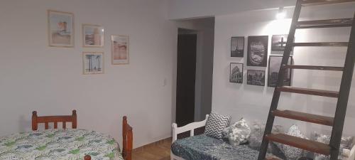 Costa AzulDept. Miramar (1 cuadra del mar y 3 de SanBer.)的卧室设有梯子和床,墙上挂有图片