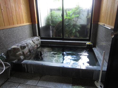 由布市湯布院 おやど花の湯yufuin oyado hananoyu的窗户浴室里的鱼塘