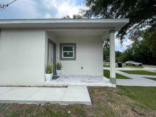奥兰多3BD/2BTH Home Near Downtown Orlando的白色的小房子,设有门廊和车道