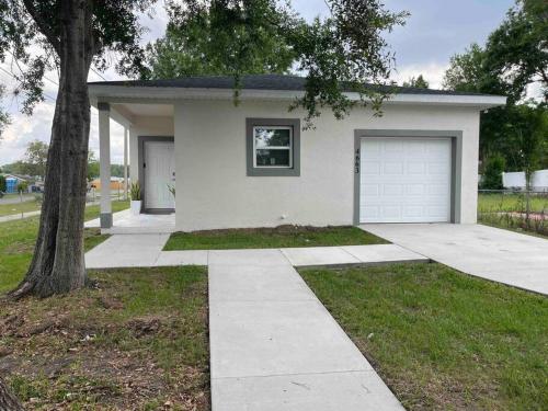 奥兰多3BD/2BTH Home Near Downtown Orlando的一间白色的房子,有车库和一棵树