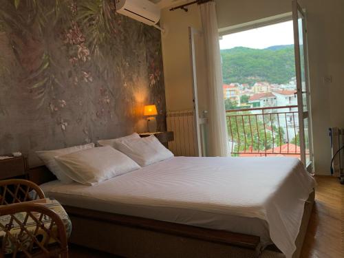 伊加洛Apartmani SRNA, Igalo的一间卧室设有一张带窗户的床,享有美景