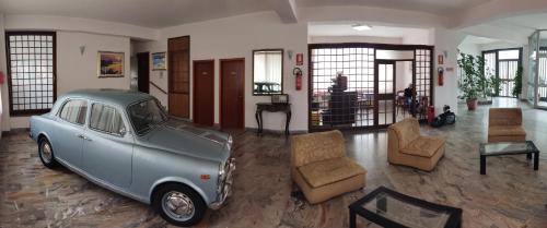圣乔瓦尼镇Hotel Il Dollaro的停在客厅的旧蓝色汽车