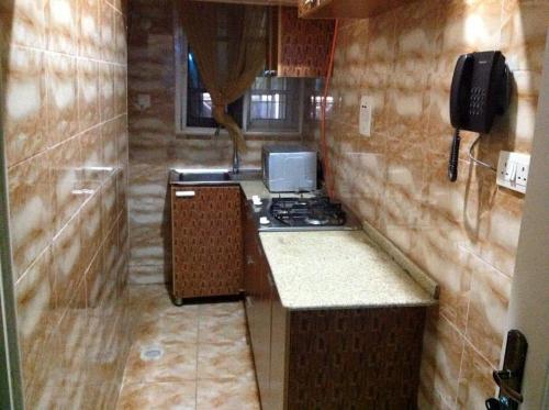 JiduDazzle Hotels and Apartments的小厨房配有炉灶和水槽