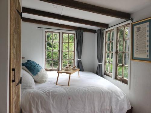 贝林真Bellingen Hideaway Tiny Home- Breathe. Discover. Renew.的卧室配有一张白色的床和一张桌子