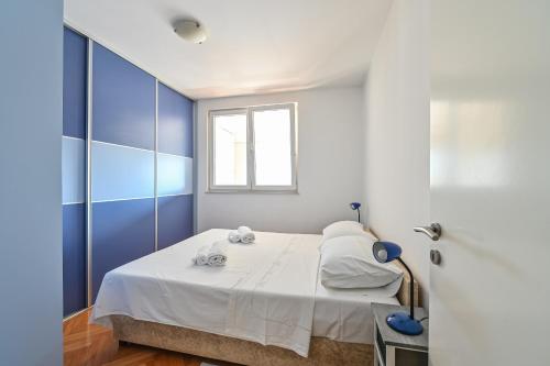 扎达尔Apartment Dada Zadar -Excellent apartment nearby old city的一间卧室配有蓝色和白色的墙壁。