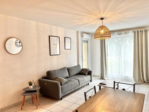 普瓦捷Apparthotel - Horizon Poitevin的客厅配有沙发和桌子