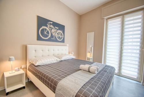 阿韦利诺B&B Civico 168 Bellerofonte的卧室配有一张床,墙上挂着一张自行车照片