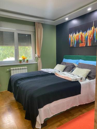 斯雷姆斯卡米特罗维察Apartman Diana的卧室配有一张大床,墙上挂有绘画作品