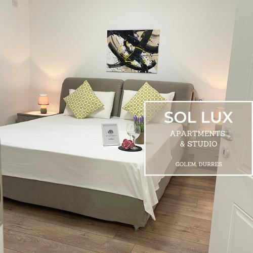 都拉斯SOL Lux Apartments 1st Floor的一间卧室配有带白色床单和枕头的床。