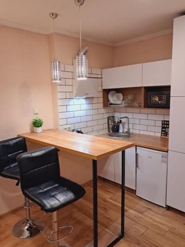 伊万诺-弗兰科夫斯克New modern apartments in the center的厨房配有木桌和两把椅子
