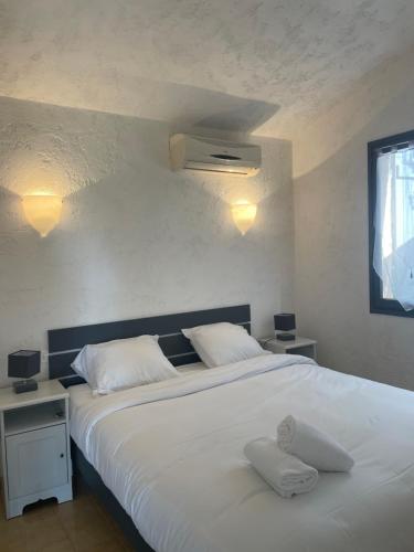 维琪奥港Residence "U LATONU"的卧室配有一张带两个枕头的大白色床