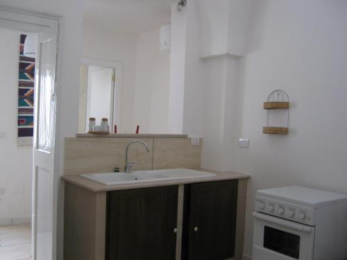 诺沃利B&B A casa delle zie的白色的厨房设有水槽和炉灶。