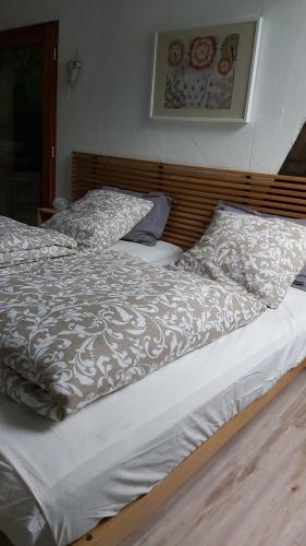 WinkelHerbes et collines的一张带白色棉被和两个枕头的床