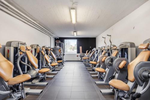 UndenäsBruksgården Bed&Breakfast的健身房设有一排健身自行车和跑步机