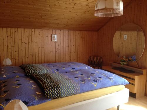 StaldenriedStaldenried Ferienwohnung的一间卧室配有一张带蓝色棉被的床