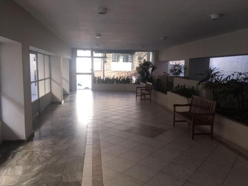 弗洛里亚诺波利斯Apto climatizado -garagem的建筑里带椅子和植物的走廊