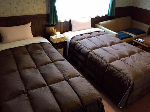 日光Morinouta的酒店客房,配有两张床和椅子