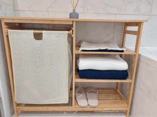 圣但尼Sweet place的浴室内带毛巾和鞋子的木制架子